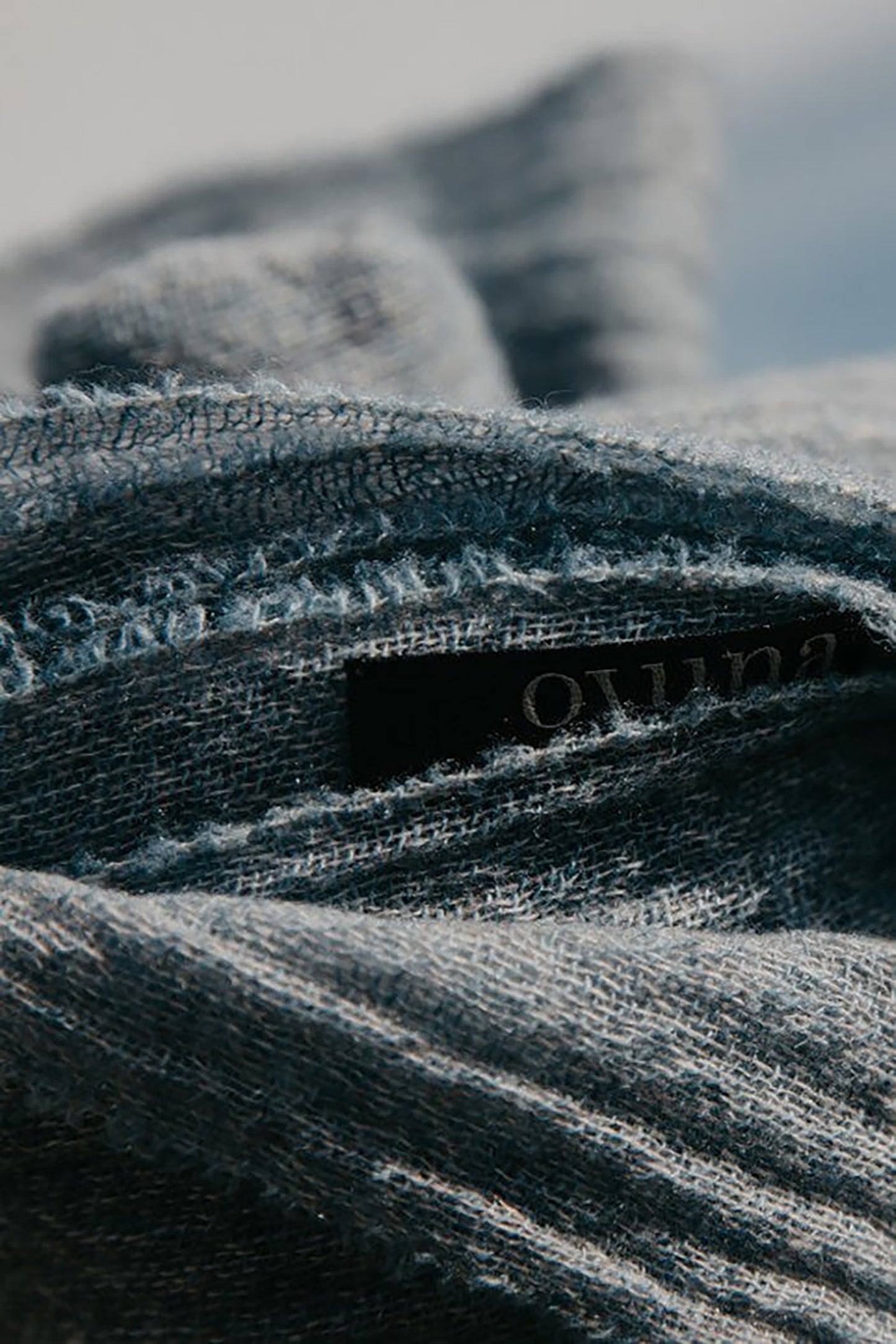 Close-up of a textured fabric with a brand label on a blurred background