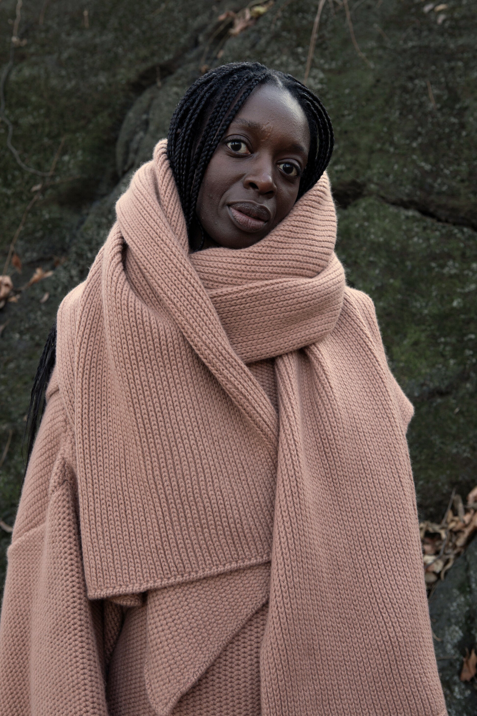 A model wearing the Mocha shawl.
 Achunky knit shawl made from 100% Mongolian cashmere. The shawl comes in a soft, muted shade of beige, enhancing its cozy and comforting appearance