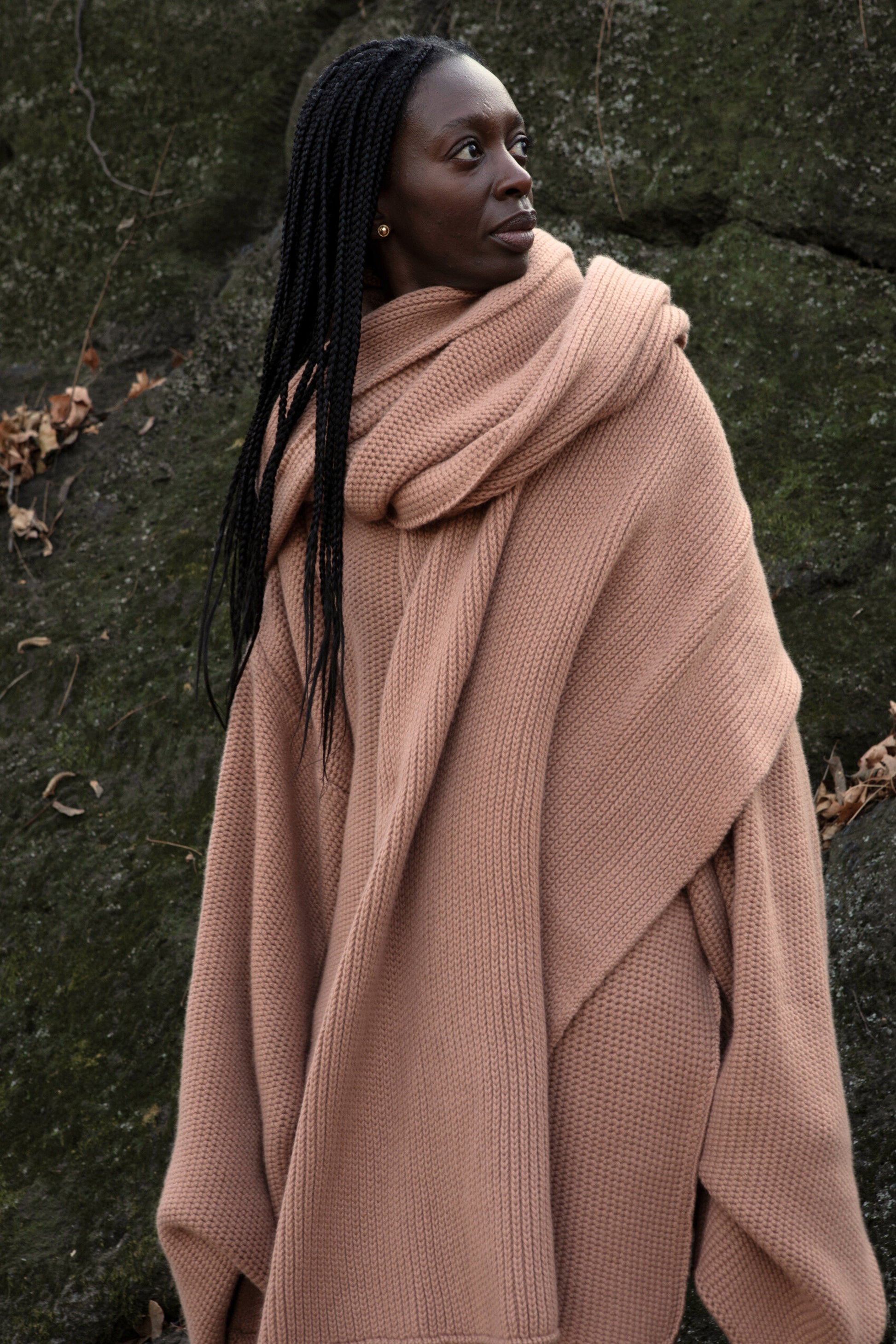 A model wearing the Mocha shawl.
 Achunky knit shawl made from 100% Mongolian cashmere. The shawl comes in a soft, muted shade of beige, enhancing its cozy and comforting appearance