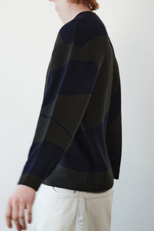 This image features the Arouc Sweater, a stylish and cozy garment perfect for everyday wear. The sweater displays a boxy silhouette and is crafted with a knitted jacquard print in a striking combination of black and navy blue.