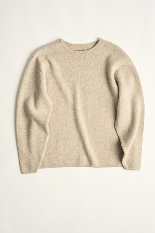 This image features the Axa Sweater, highlighted in a minimalistic style with a feather color. The sweater showcases an oversized fit with distinct drop shoulders and sculpted, rounded sleeves.