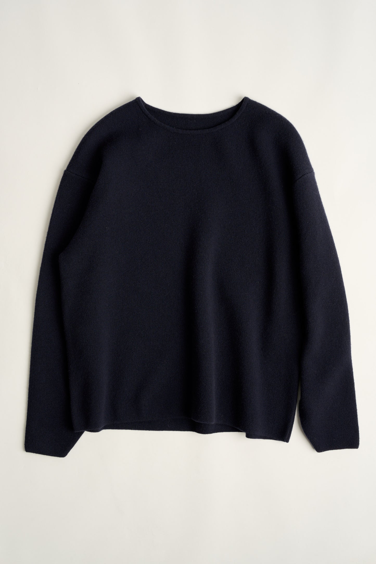 This image features the Axa Sweater, highlighted in a minimalistic style with a ocean color. The sweater showcases an oversized fit with distinct drop shoulders and sculpted, rounded sleeves.
