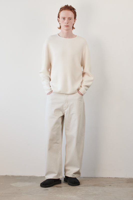 This image features the Axa Sweater, highlighted in a minimalistic style with a ivory color. The sweater showcases an oversized fit with distinct drop shoulders and sculpted, rounded sleeves.