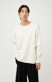 Person wearing Axa oversized fit cashmere sweater with drop shoulders and rounded sleeves in colour Ivory.