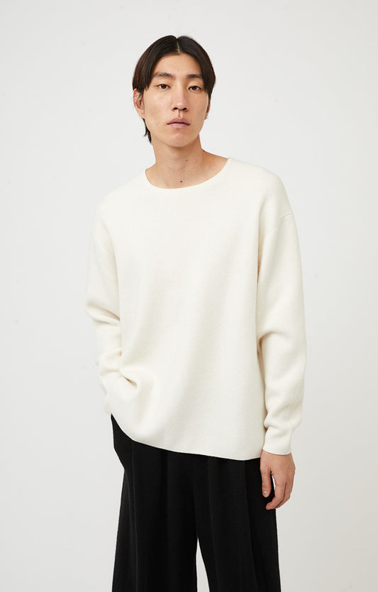 This image features the Axa Sweater, highlighted in a minimalistic style with a ivory color. The sweater showcases an oversized fit with distinct drop shoulders and sculpted, rounded sleeves.