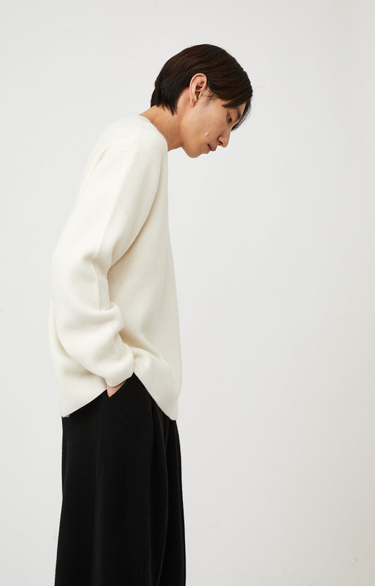 This image features the Axa Sweater, highlighted in a minimalistic style with a ivory color. The sweater showcases an oversized fit with distinct drop shoulders and sculpted, rounded sleeves.
