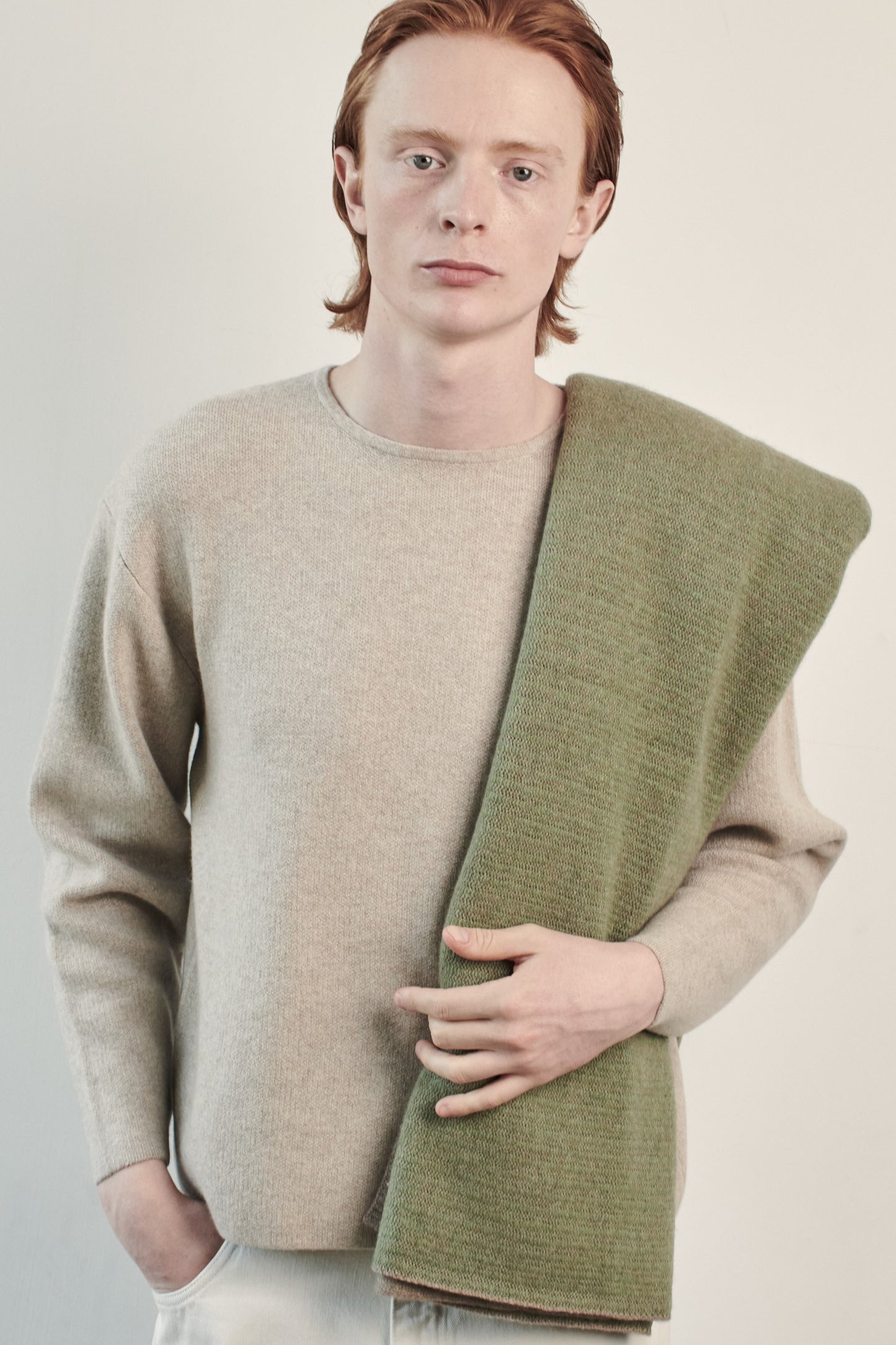 This image features the Axa Sweater, highlighted in a minimalistic style with a feather color. The sweater showcases an oversized fit with distinct drop shoulders and sculpted, rounded sleeves.