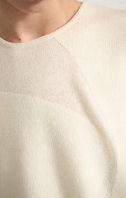 Woman wearing Duon cashmere top in Ivory. 