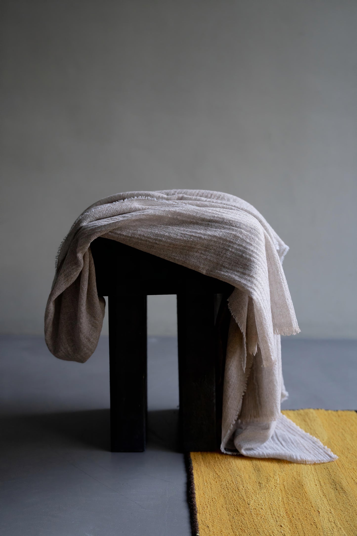 An Esra mist coloured throw draped over a stool