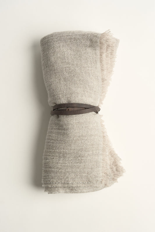 An Esra mist coloured throw on a white background with a brown belt