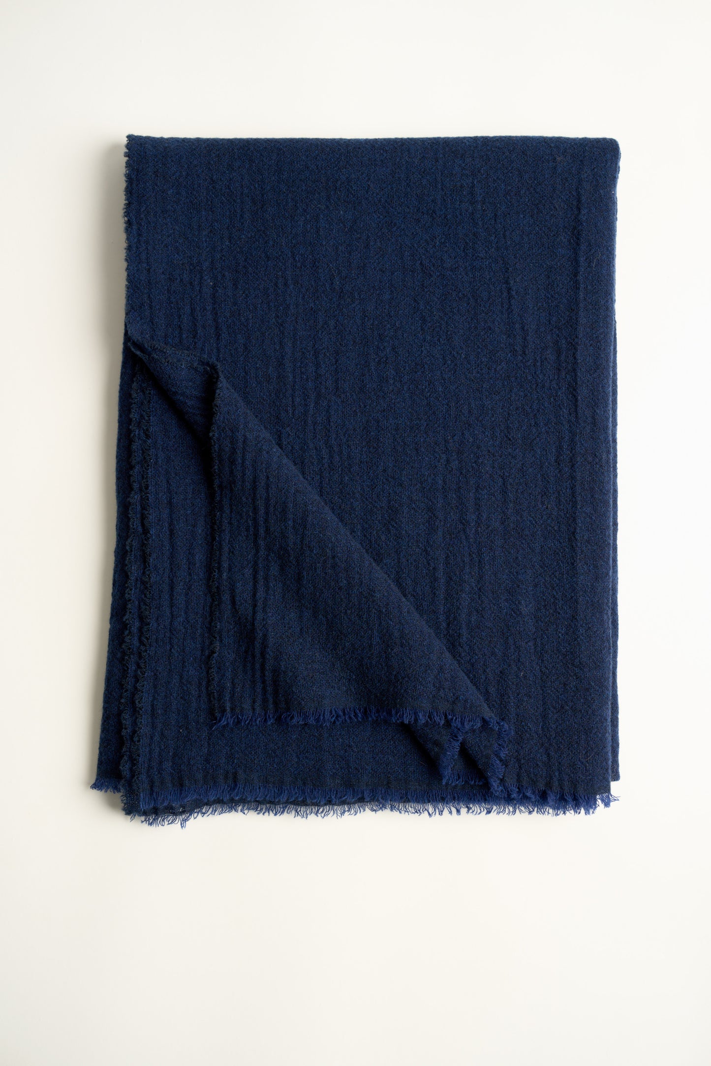 A navy blue cashmere throw with a soft, airy weave, displayed on a plain background.