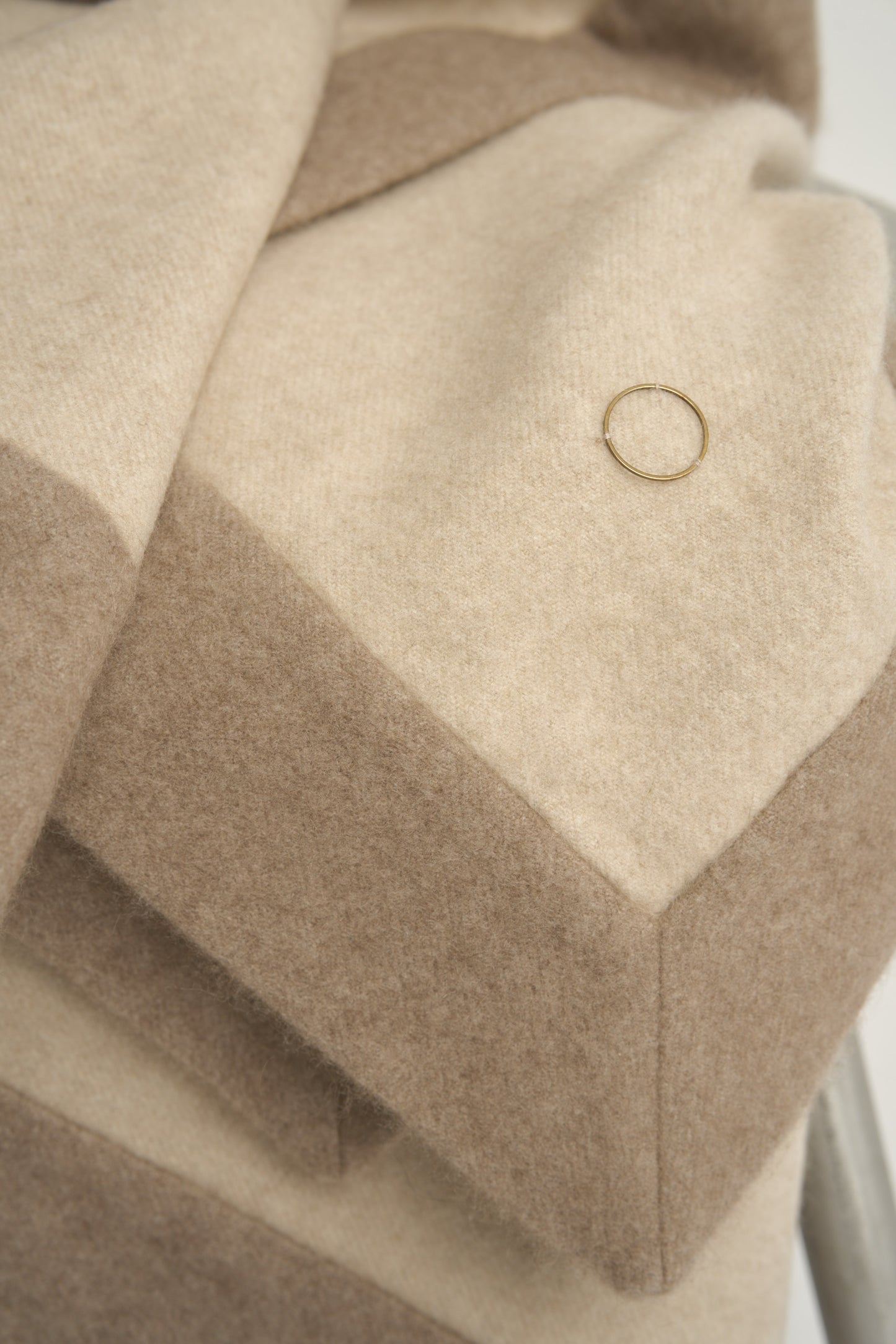 This image displays the Etra Big Bedspread. Presented on a simple metal frame to emphasize its soft texture and sophisticated color palette, the bedspread exudes opulence and comfort.
