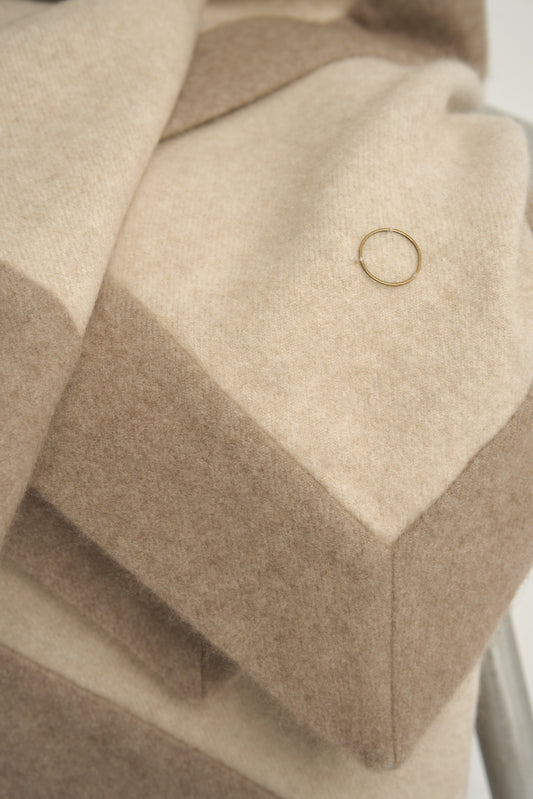 This image displays the Etra Big Bedspread. Presented on a simple metal frame to emphasize its soft texture and sophisticated color palette, the bedspread exudes opulence and comfort.