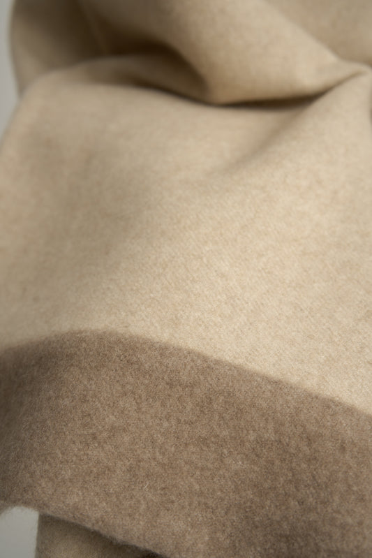 A king-size bedspread in beige & taupe, draped over a chair with a neutral background.