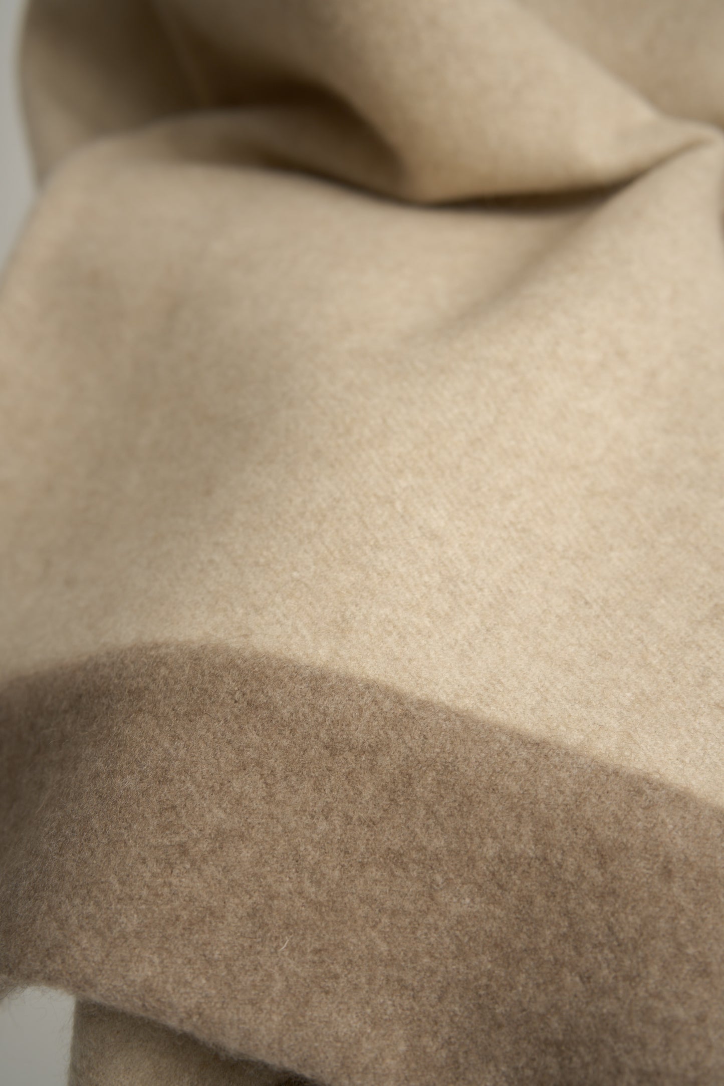 This image displays the Etra Big Bedspread. Presented on a simple metal frame to emphasize its soft texture and sophisticated color palette, the bedspread exudes opulence and comfort.