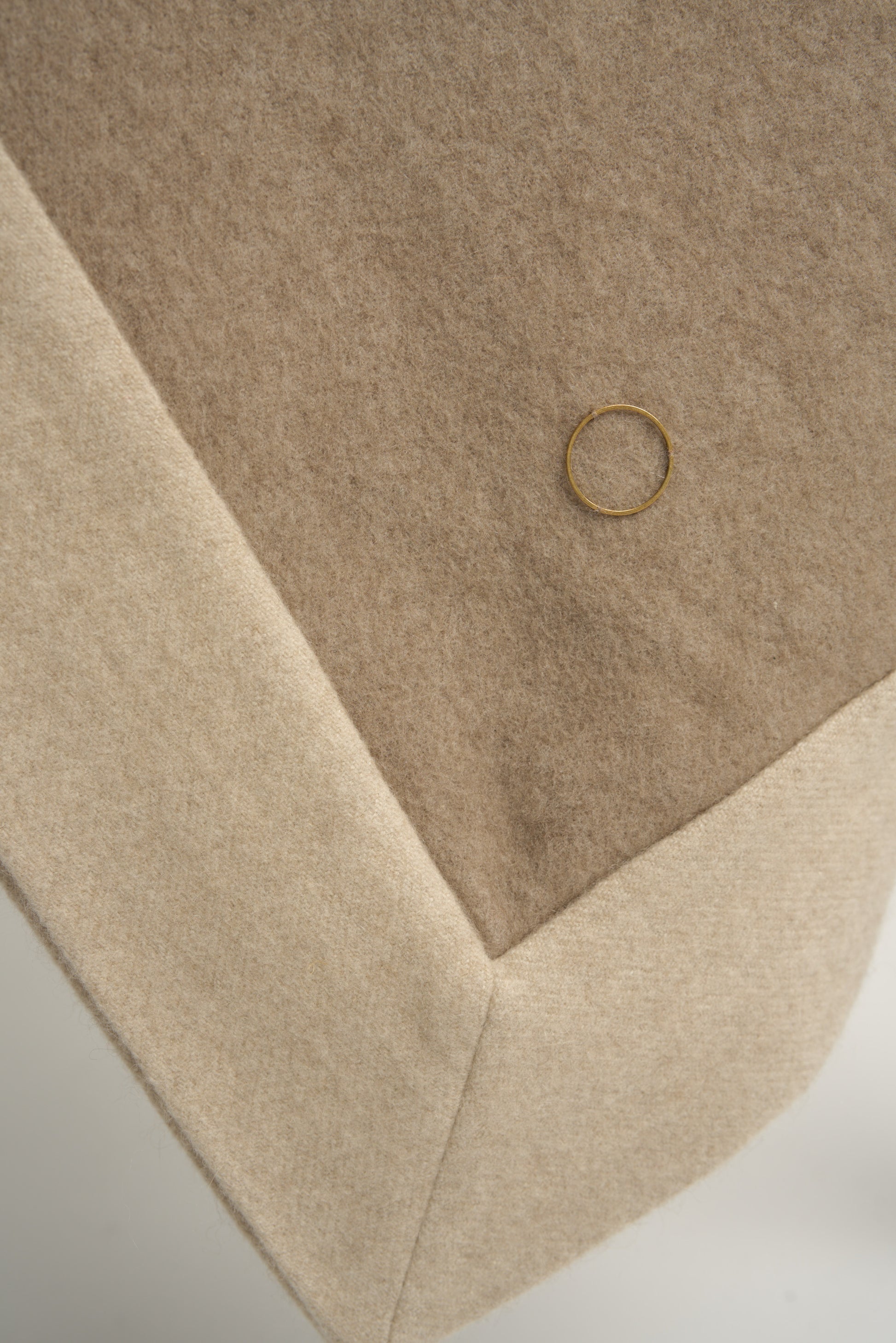 A king-size bedspread in taupe & beige, draped over a chair with a neutral background.