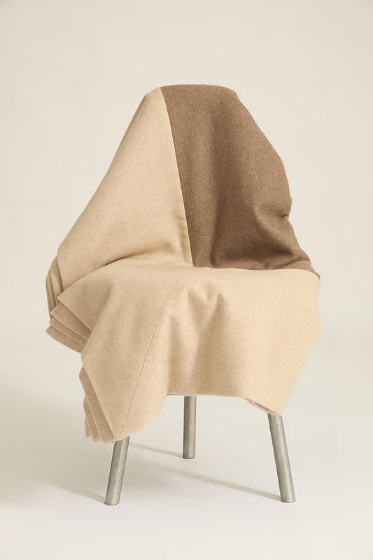 A king-size bedspread in taupe & beige, draped over a chair with a neutral background.