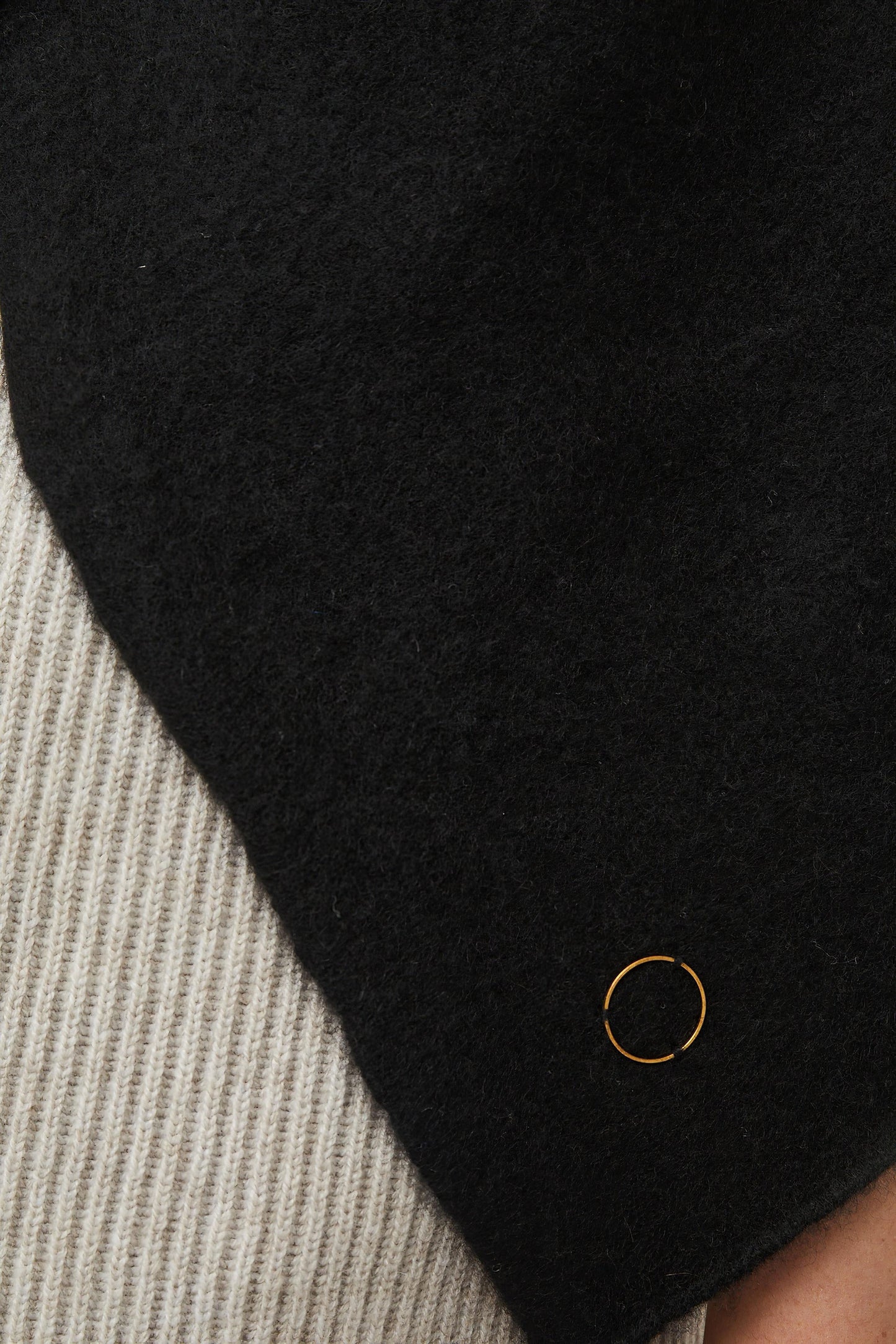 This image features the Feltra Shawl, an elegant and warm accessory made from felted cashmere, emphasizing pure simplicity and luxury. The shawl is presented in a deep, rich black color, enhancing its sophisticated and sleek appearance.