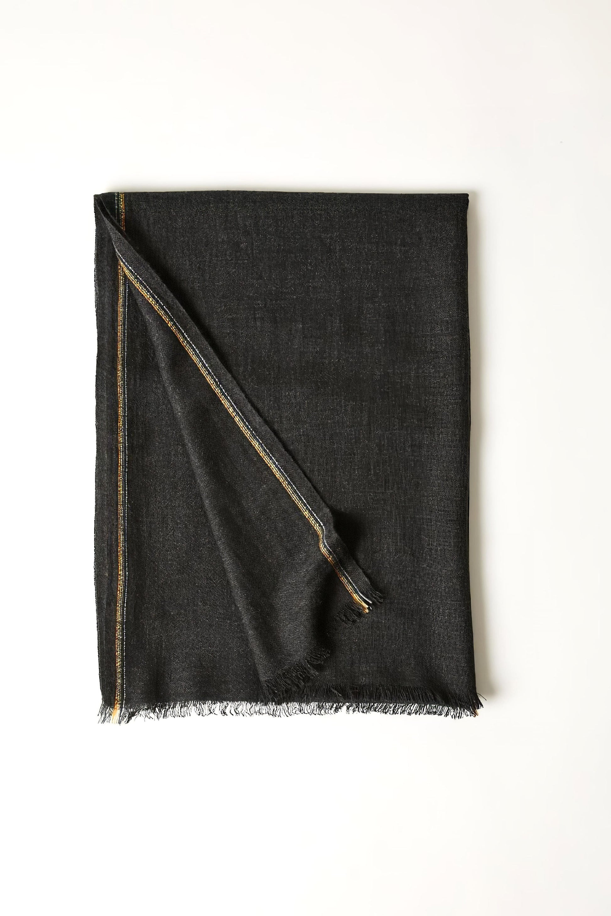 An image of a folded charcoal cashmere throw with contrast stripes and fringes.