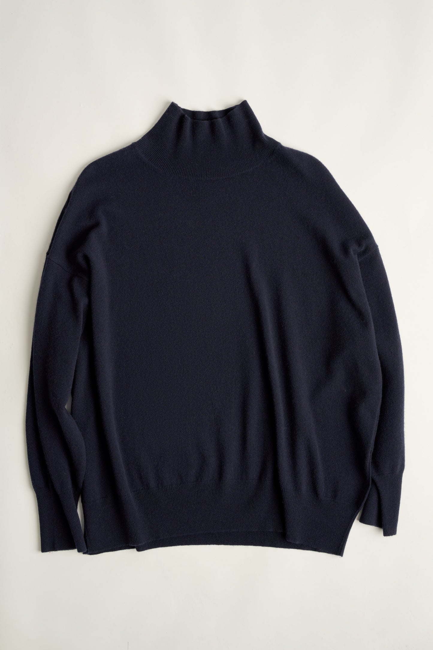 This image features the Kotto Sweater, characterized by its high-neck design and relaxed fit. The sweater is crafted from a classic jersey knit, showcased in a soft, ocean color.