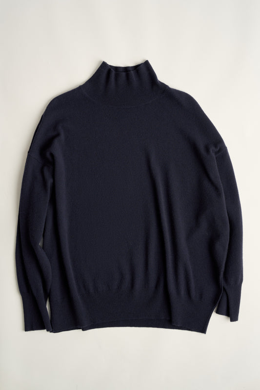 This image features the Kotto Sweater, characterized by its high-neck design and relaxed fit. The sweater is crafted from a classic jersey knit, showcased in a soft, ocean color.