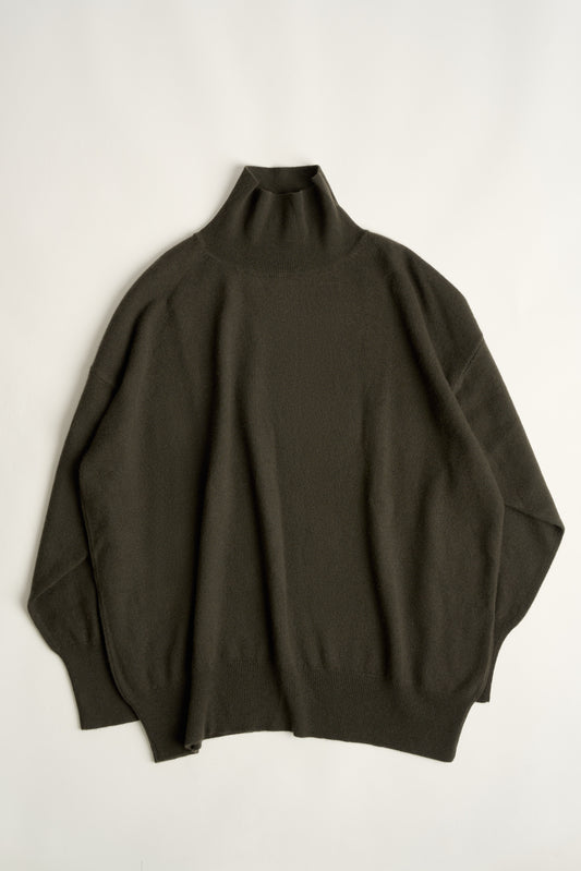 This image features the Kotto Sweater, characterized by its high-neck design and relaxed fit. The sweater is crafted from a classic jersey knit, showcased in a soft, forest color.