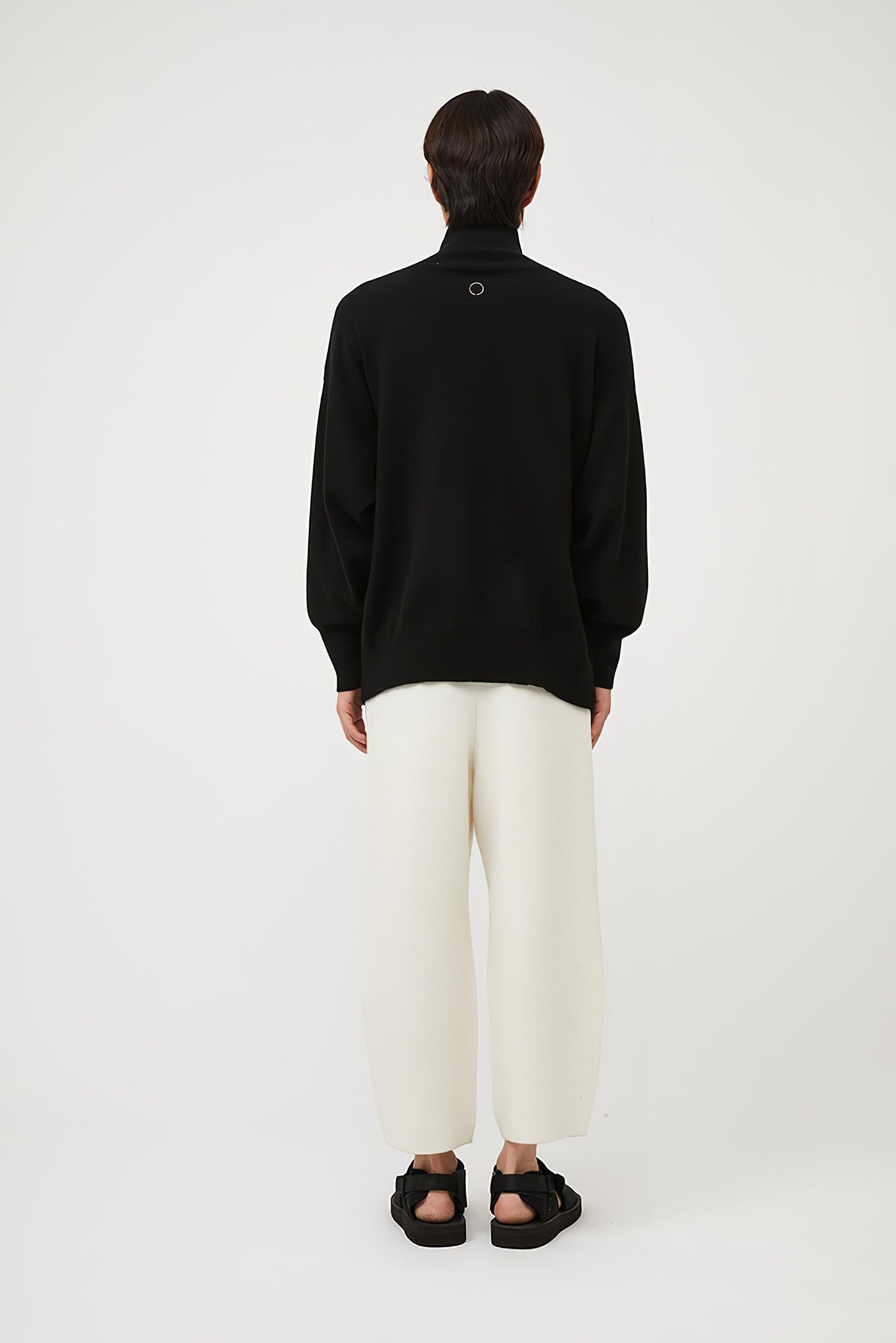 This image features the Kotto Sweater, characterized by its high-neck design and relaxed fit. The sweater is crafted from a classic jersey knit, showcased in a soft, black color.