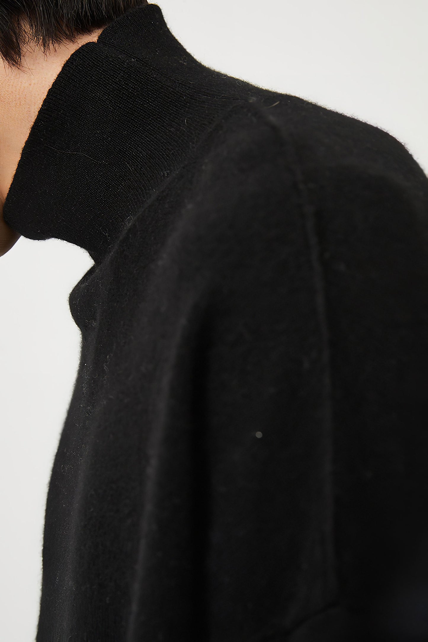 This image features the Kotto Sweater, characterized by its high-neck design and relaxed fit. The sweater is crafted from a classic jersey knit, showcased in a soft, black color.