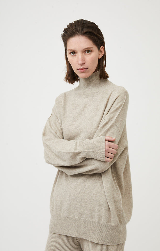 Person wearing Kotto knitted oversized cashmere sweater in colour Feather.