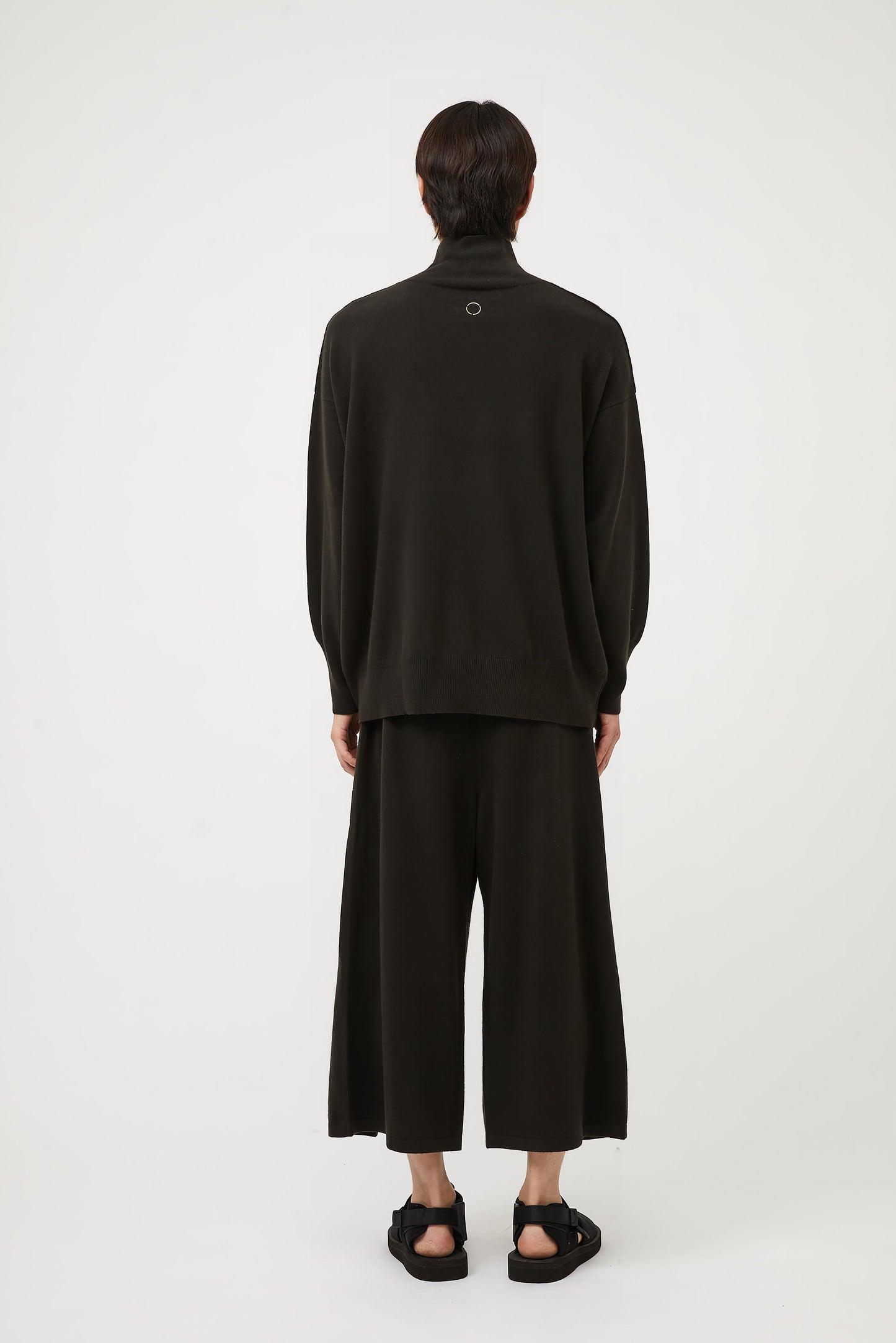 This image features the Kotto Sweater, characterized by its high-neck design and relaxed fit. The sweater is crafted from a classic jersey knit, showcased in a soft, forest color.
