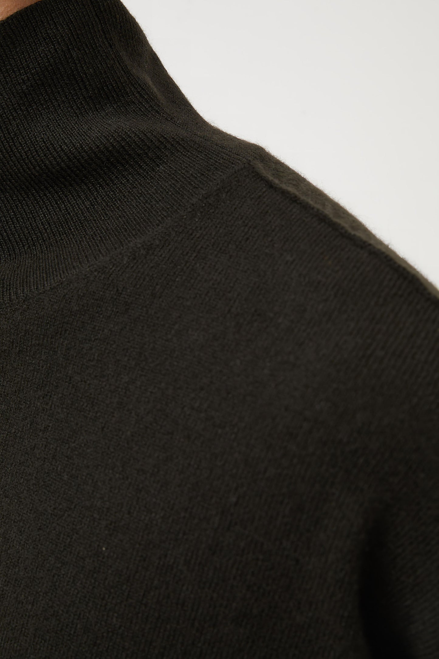 This image features the Kotto Sweater, characterized by its high-neck design and relaxed fit. The sweater is crafted from a classic jersey knit, showcased in a soft, forest color.