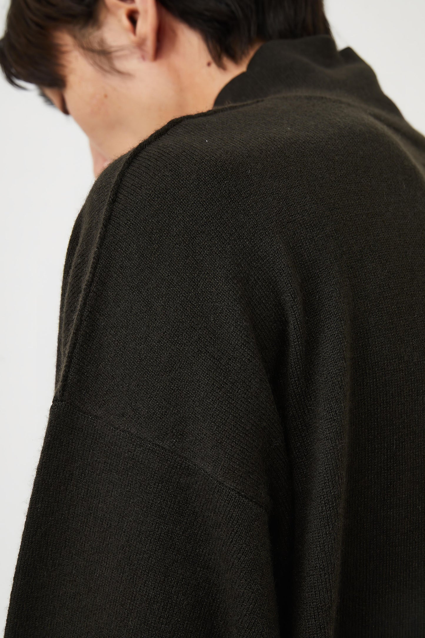 This image features the Kotto Sweater, characterized by its high-neck design and relaxed fit. The sweater is crafted from a classic jersey knit, showcased in a soft, forest color.