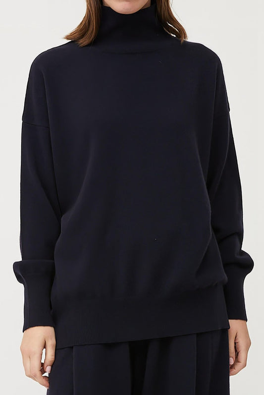 This image features the Kotto Sweater, highlighting its high-neck design and snug, comfortable fit. The sweater is presented in a classic, versatile ocean color, which enhances its elegant and timeless appeal.