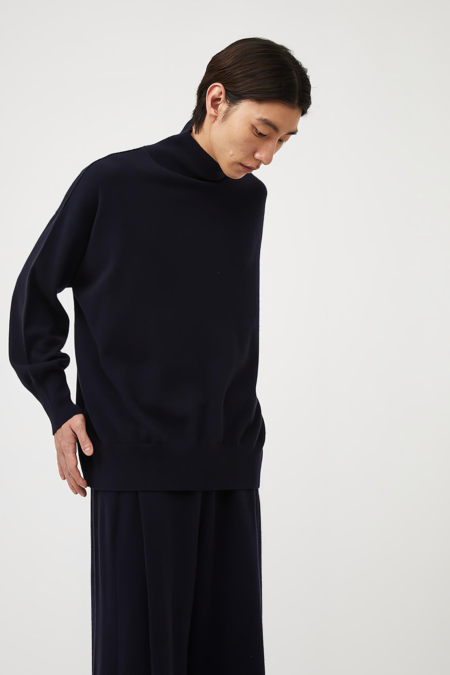 This image features the Kotto Sweater, characterized by its high-neck design and relaxed fit. The sweater is crafted from a classic jersey knit, showcased in a soft, ocean color.