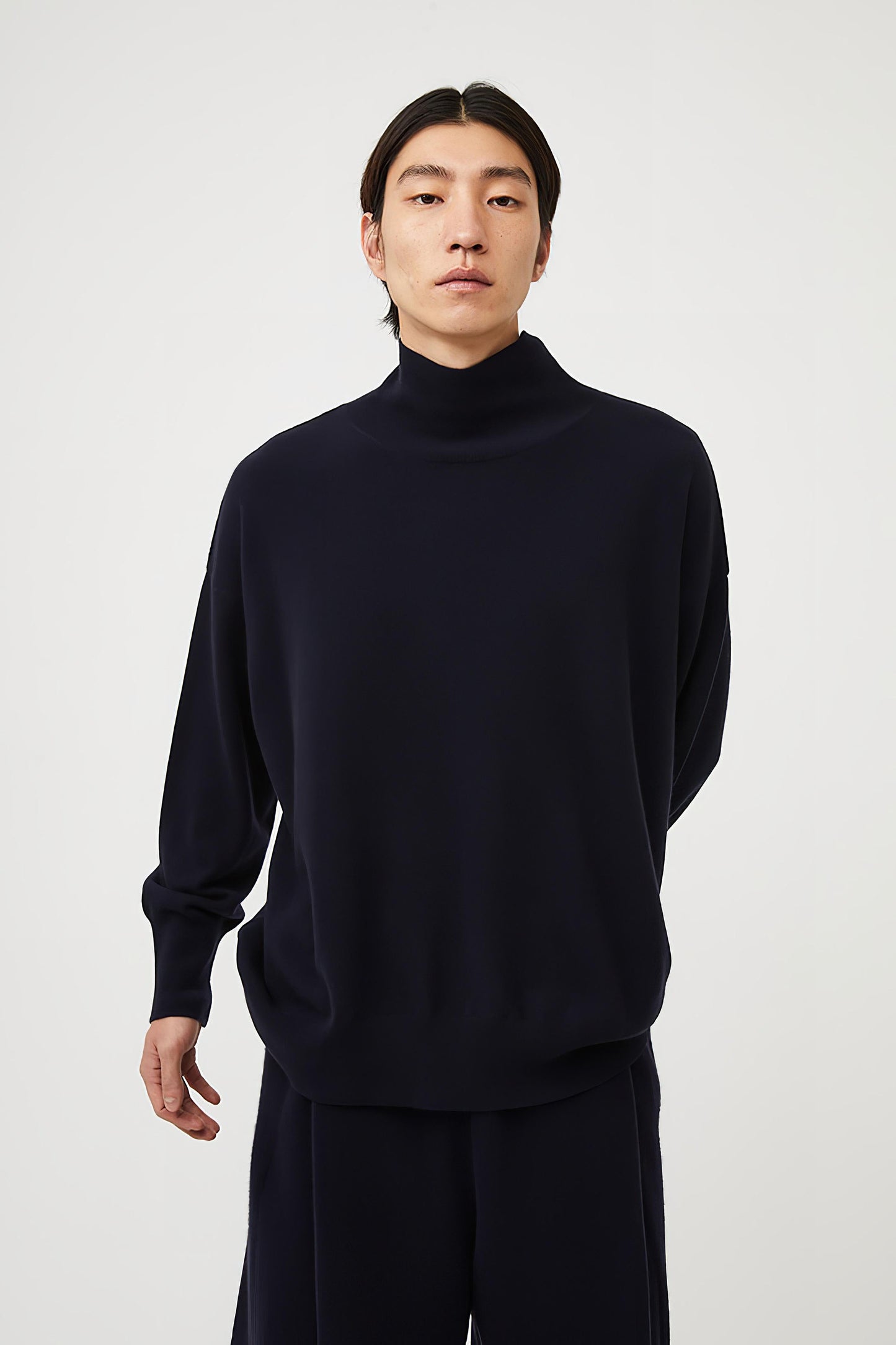 This image features the Kotto Sweater, characterized by its high-neck design and relaxed fit. The sweater is crafted from a classic jersey knit, showcased in a soft, ocean color.