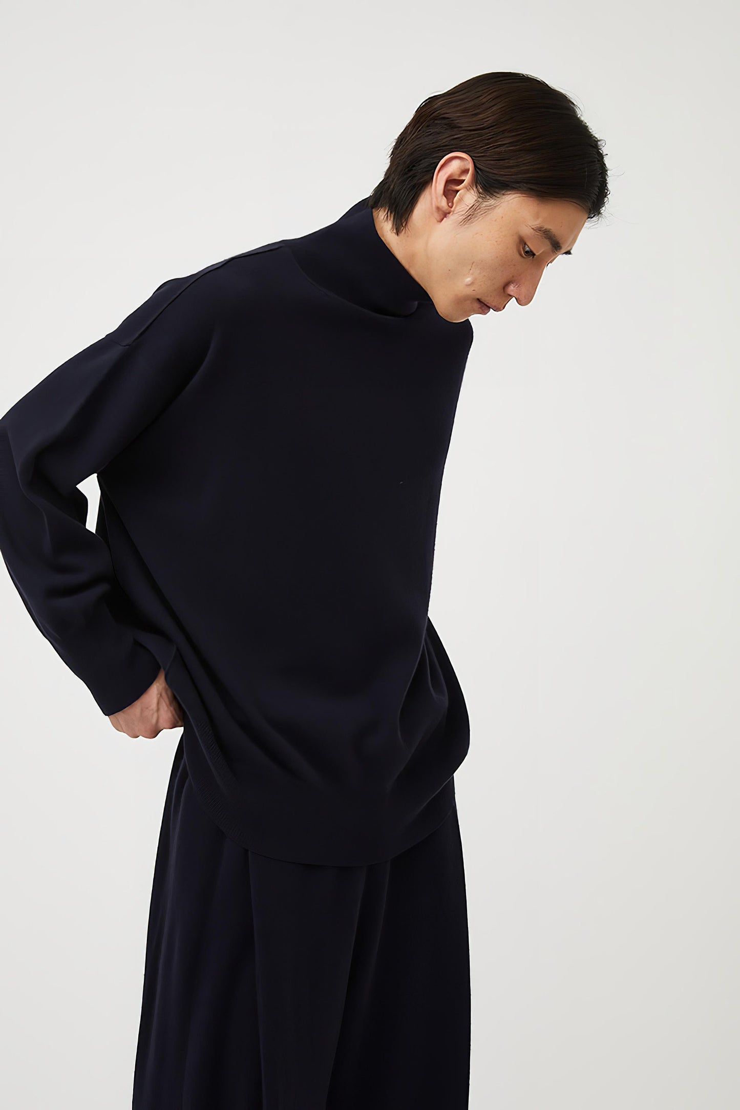 This image features the Kotto Sweater, characterized by its high-neck design and relaxed fit. The sweater is crafted from a classic jersey knit, showcased in a soft, ocean color.