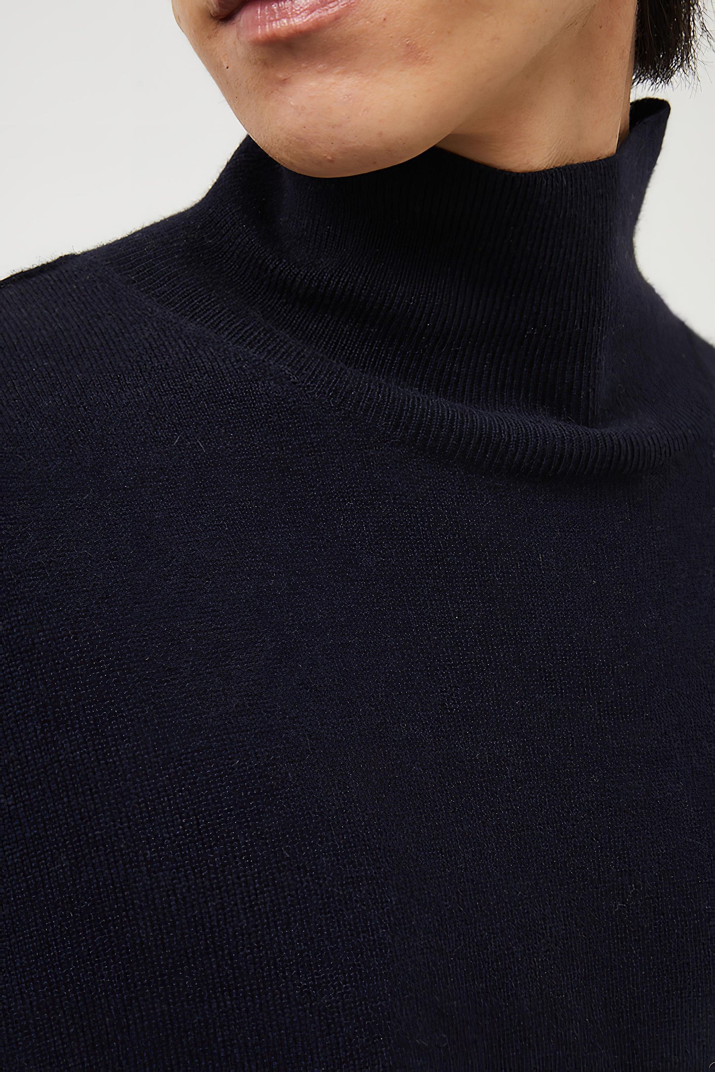 This image features the Kotto Sweater, characterized by its high-neck design and relaxed fit. The sweater is crafted from a classic jersey knit, showcased in a soft, ocean color.