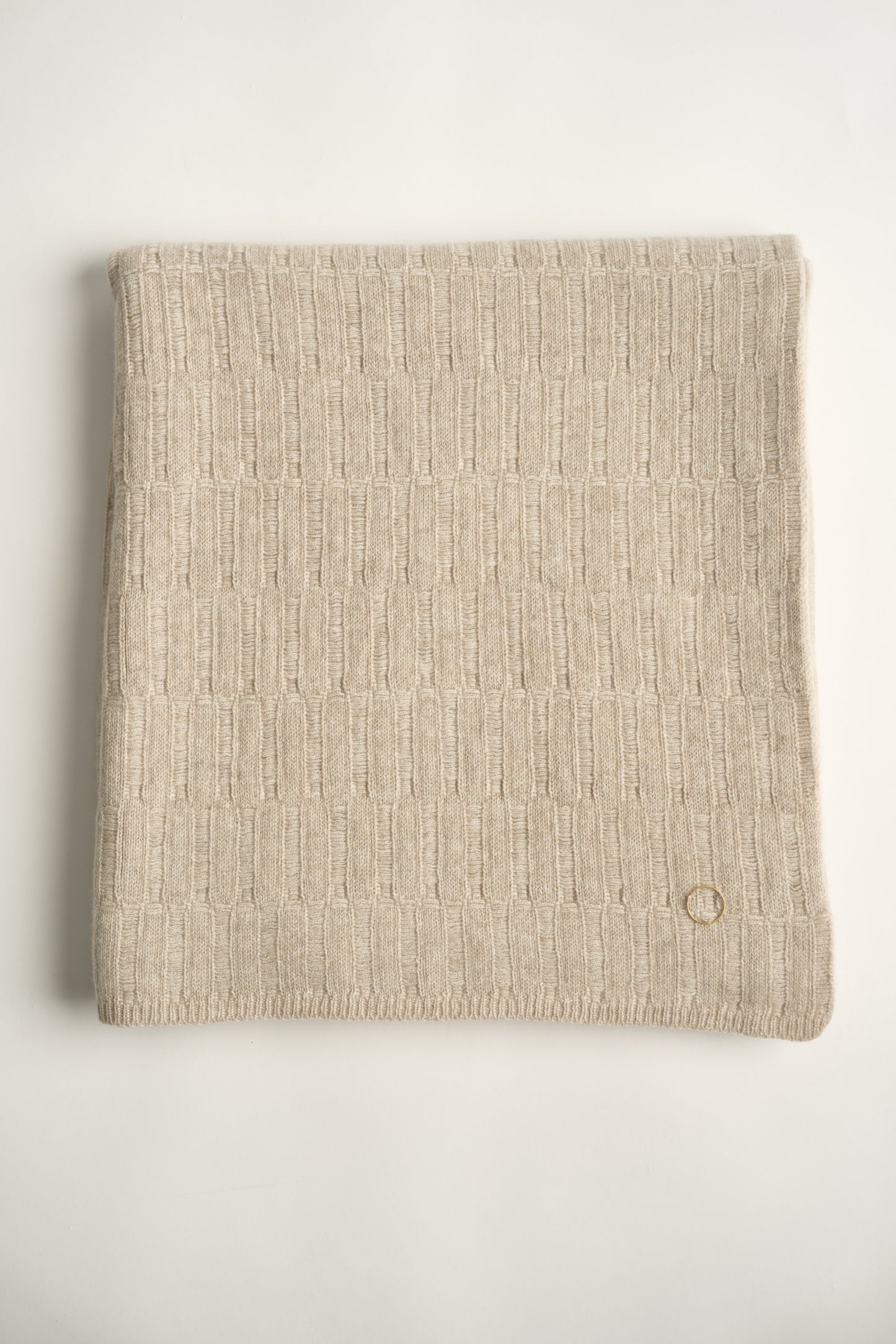 A flat lay image of a feather coloured Lake throw