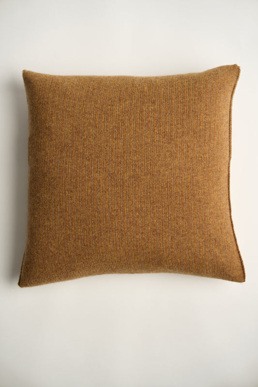 This image displays the Letra Cushion Cover, characterized by its knitted two-tone float knit design. The cushion cover features a textured, cozy appearance in a honey & taupe color, which comes across as modern and stylish.