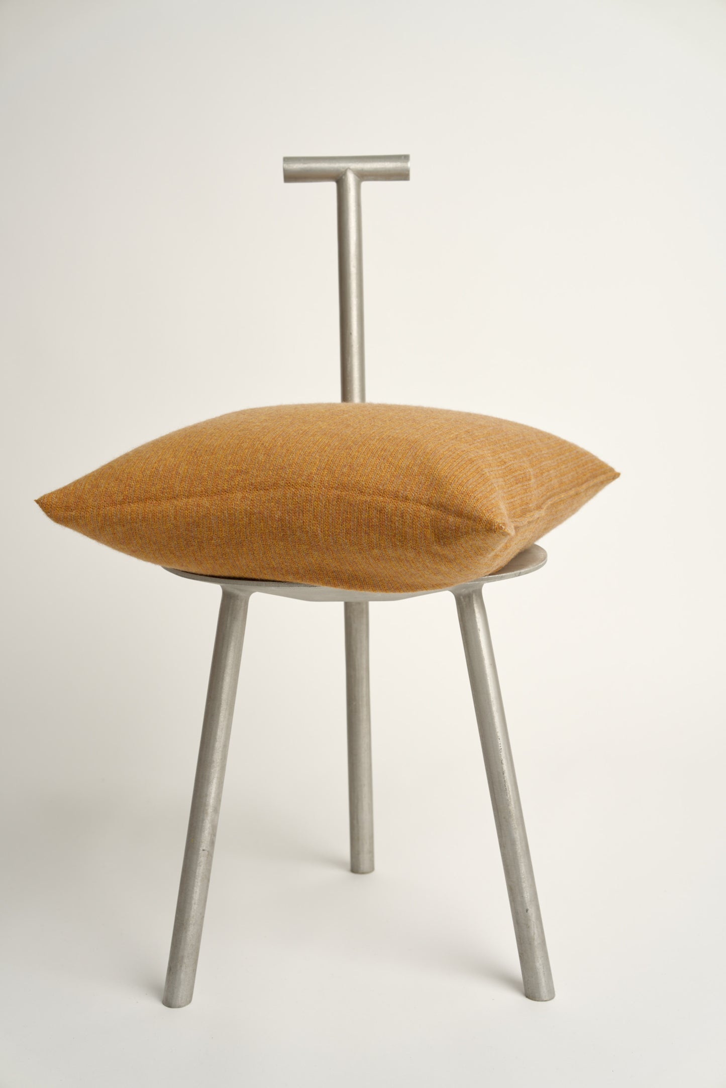 This image displays the Letra Cushion Cover, characterized by its knitted two-tone float knit design. The cushion cover features a textured, cozy appearance in a honey & taupe color, which comes across as modern and stylish.