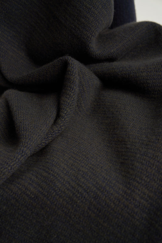 This image features the Letra Throw, a knitted, two-tone float knit throw in a warm, inviting color. The throw displays a soft, textured fabric with a stylish float knit pattern that adds depth and visual interest.