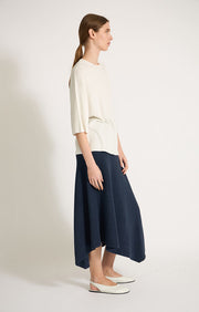 Woman wearing Kesi cotton skirt with an elasticated waistband, knitted in a textured 3D stitch in colour Indigo. 
