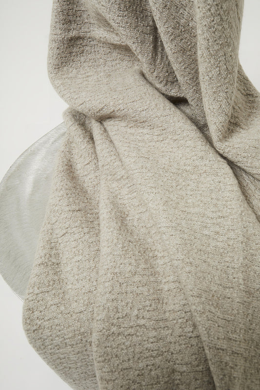 A luxurious and elegant feather coloured throw draped over a chair