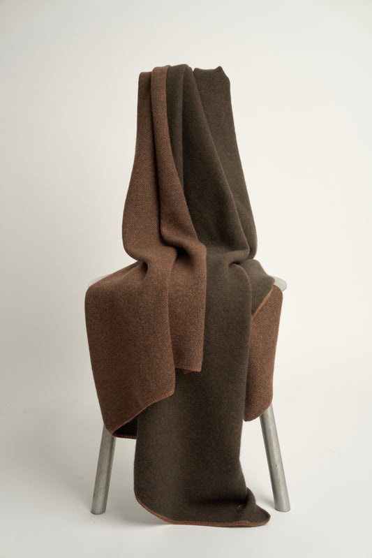This image features the Mandu Throw, a knitted microfiber throw in a two-tone brown color. The throw displays a soft, textured surface with subtle striping details, enhancing its stylish and cozy appearance.