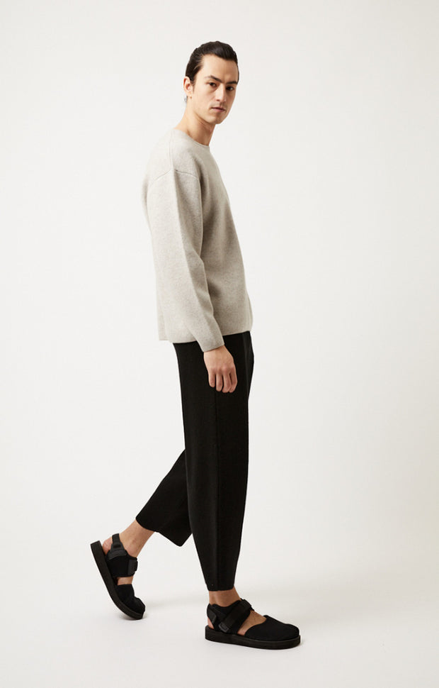 Person wearing Axa oversized fit cashmere sweater with drop shoulders and rounded sleeves in colour Feather.