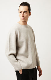 Person wearing Axa oversized fit cashmere sweater with drop shoulders and rounded sleeves in colour Feather.