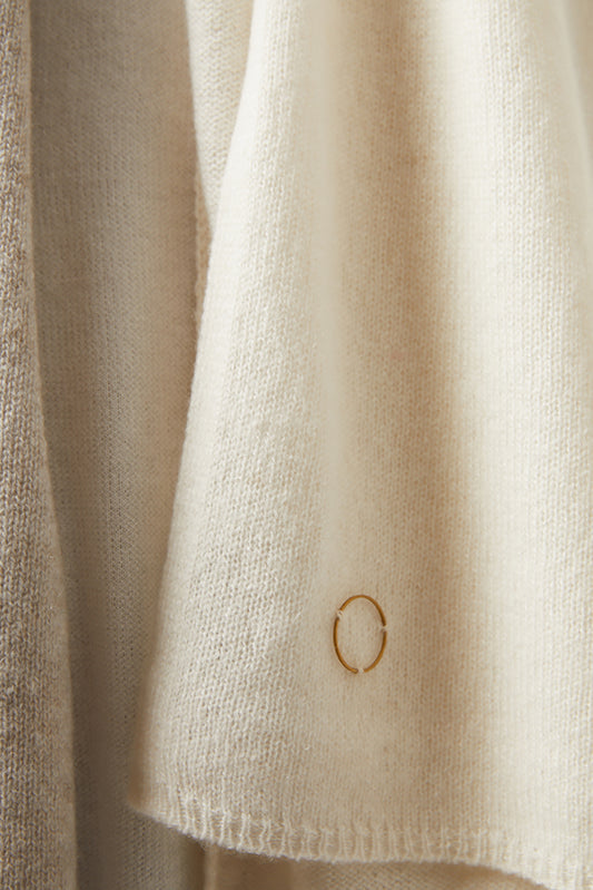 Close-up of beige shawl with a small circular detail.