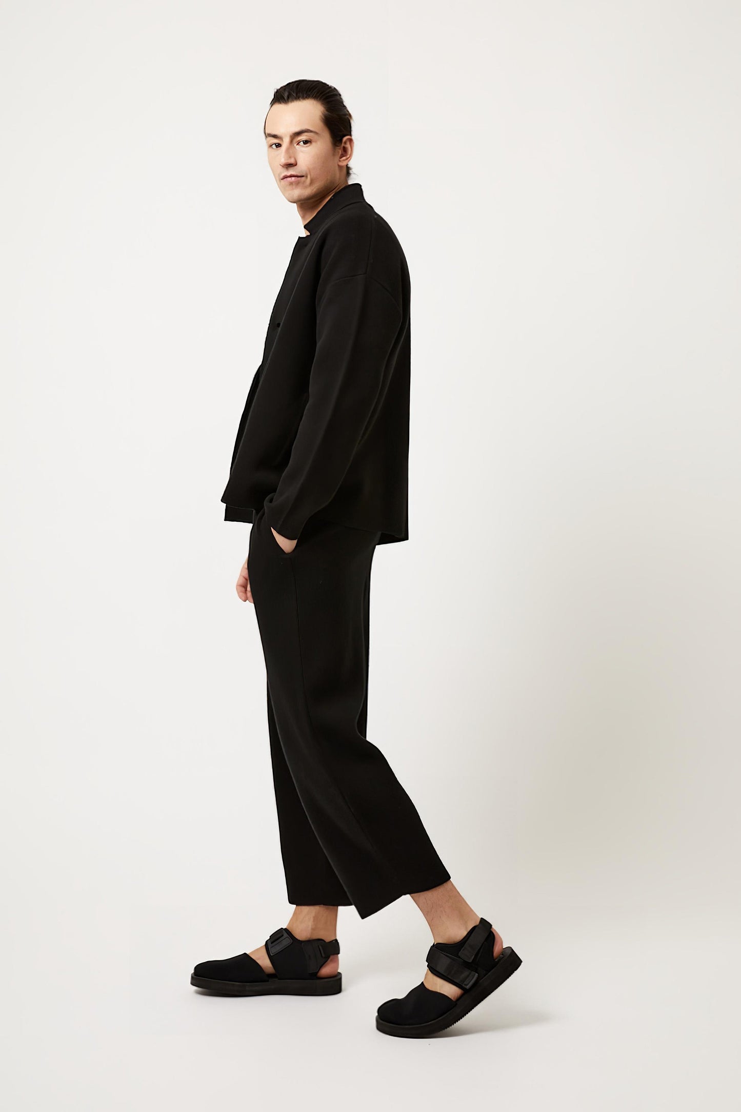 This image features a model wearing the Wind Jacket from Oyuna's core collection. The jacket is designed with a relaxed-fit and showcases a sophisticated look with its stand-up collar and welt pockets.