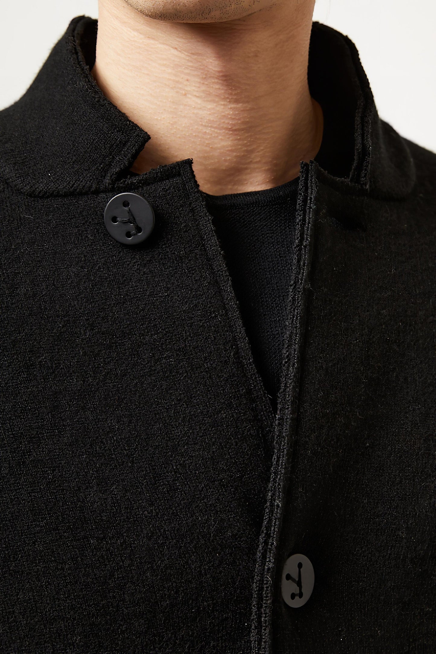 This image features a model wearing the Wind Jacket from Oyuna's core collection. The jacket is designed with a relaxed-fit and showcases a sophisticated look with its stand-up collar and welt pockets.