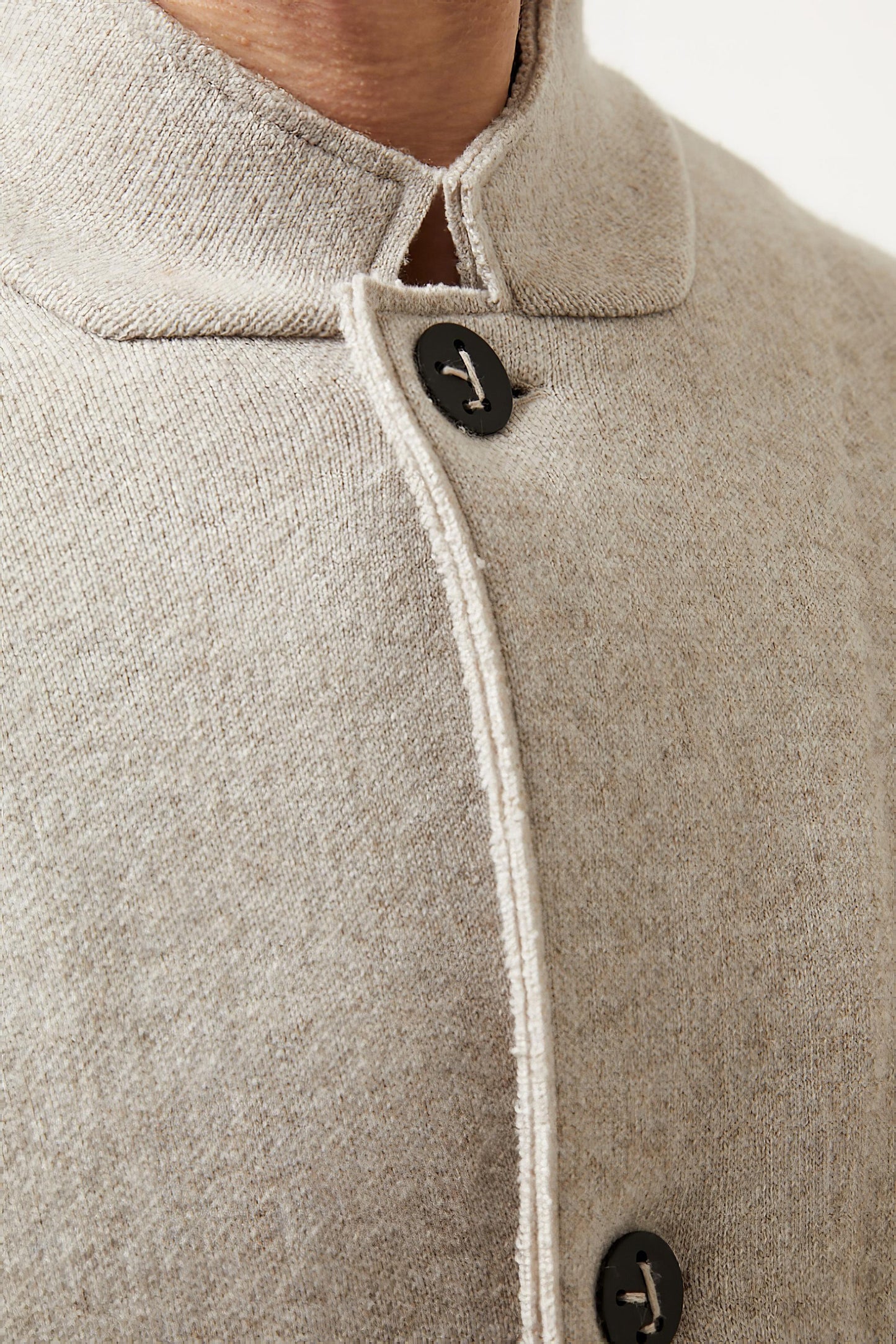 This image features a model wearing the Wind Jacket from Oyuna's core collection. The jacket is designed with a relaxed-fit and showcases a sophisticated look with its stand-up collar and welt pockets.